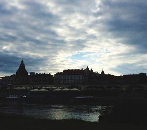 Buildings in city against cloudy sky