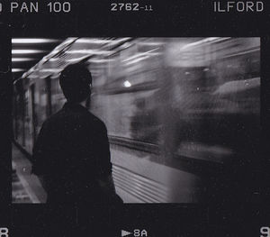 Rear view of man seen through train window