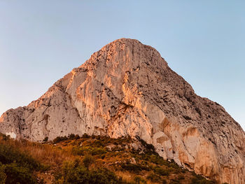 Low angle view of rocky mountain against sky