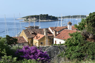 Scenic view of sea by buildings against clear sky