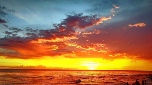 Scenic view of sea against dramatic sky during sunset