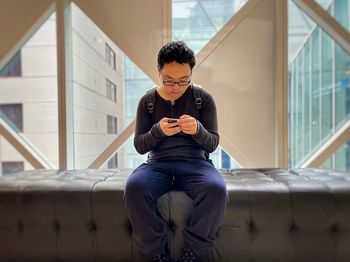 Young woman sitting on sofa at home