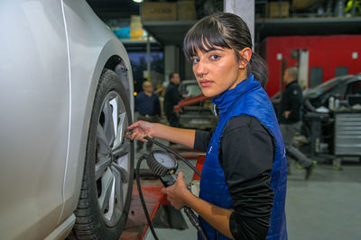 Side view of young woman holding car