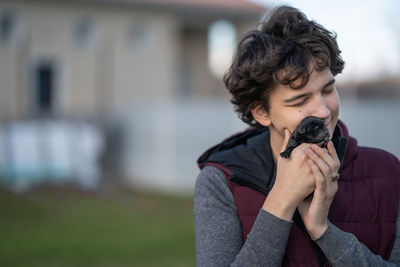 A guy with love and tenderness presses a newborn labrador puppy to his face. love concept 