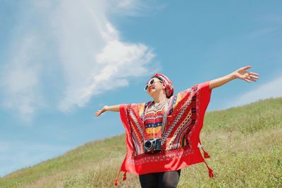 Happy elderly woman with beautiful mountain and blue sky.