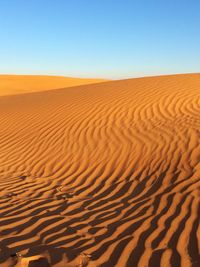 Scenic view of desert against clear blue sky