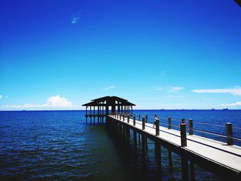 Pier over sea against blue sky