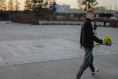 Portrait of young woman walking on road
