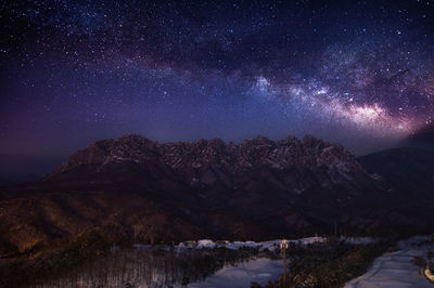 Scenic view of mountains against sky at night