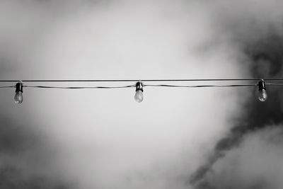 Low angle view of light bulbs against sky