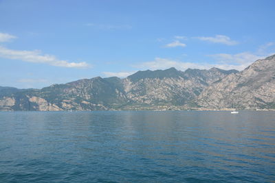 Scenic view of sea and mountains against sky