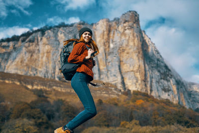 Woman standing on rock against mountain