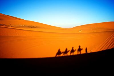 Scenic view of desert against clear sky during sunset