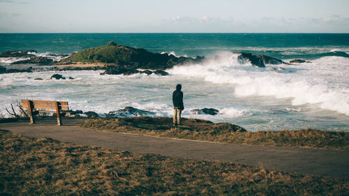 Rear view of people looking at sea against sky