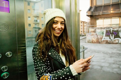 Portrait of smiling young woman using smart phone