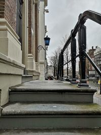 Bridge over street amidst buildings against sky