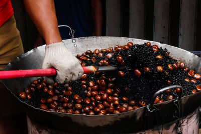 Close-up of person roasting chestnuts