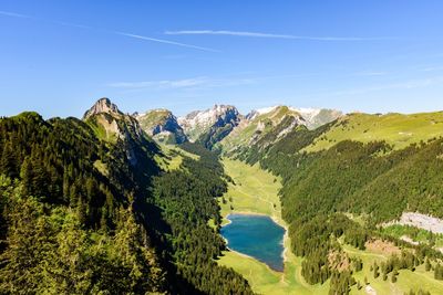 Scenic view of sea and mountains against blue sky