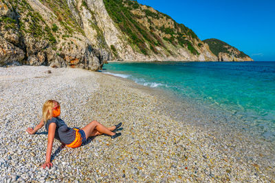 Full length of man relaxing on beach