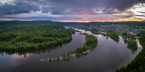 Scenic view of river against sky at sunset