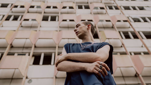 Low angle view of man standing against building in city 