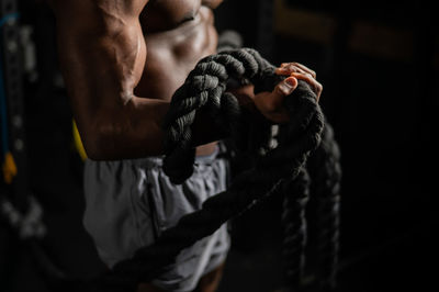 Low section of man holding rope