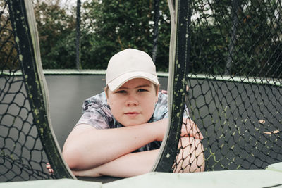 Teen boy lying on a trampoline with crossed arms