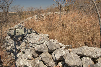 View of rocks on landscape against sky