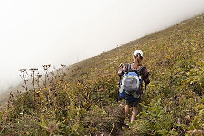 Rear view of people on mountain against sky