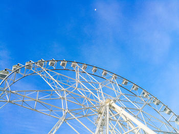 Low angle view of ferris wheel against blue sky