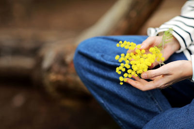 Midsection of woman holding flower