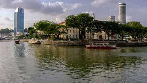Scenic view of river by buildings against sky