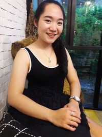 Portrait of smiling young woman sitting outdoors