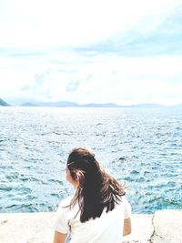 Rear view of woman looking at sea against sky