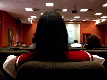 Rear view of woman sitting in subway