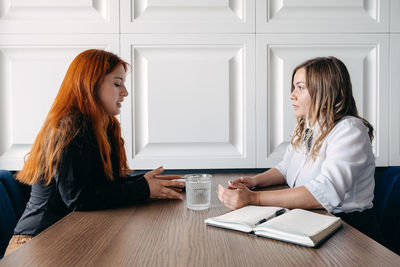 Side view of women talking with psychotherapist