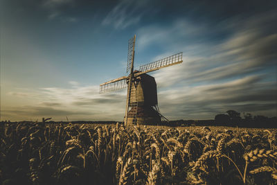 Traditional windmill on field against sky