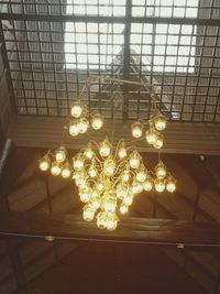 Low angle view of illuminated light bulbs hanging from ceiling