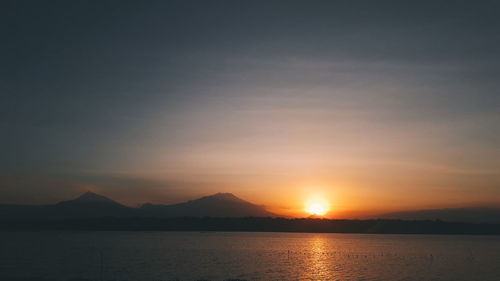 Scenic view of silhouette mountains against sky during sunset