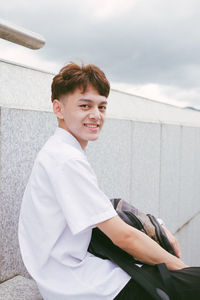 Portrait of smiling young woman against sky