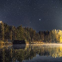 Scenic view of lake against sky at night