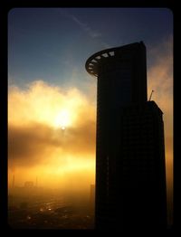 Low angle view of tower against sky at sunset