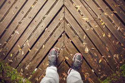 Low section of man standing on wooden floor