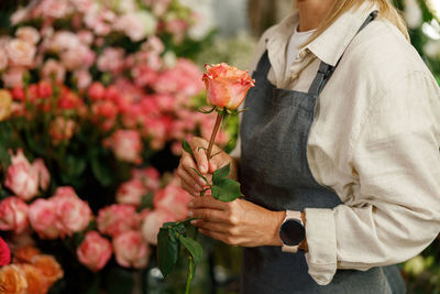 Midsection of woman holding flowers