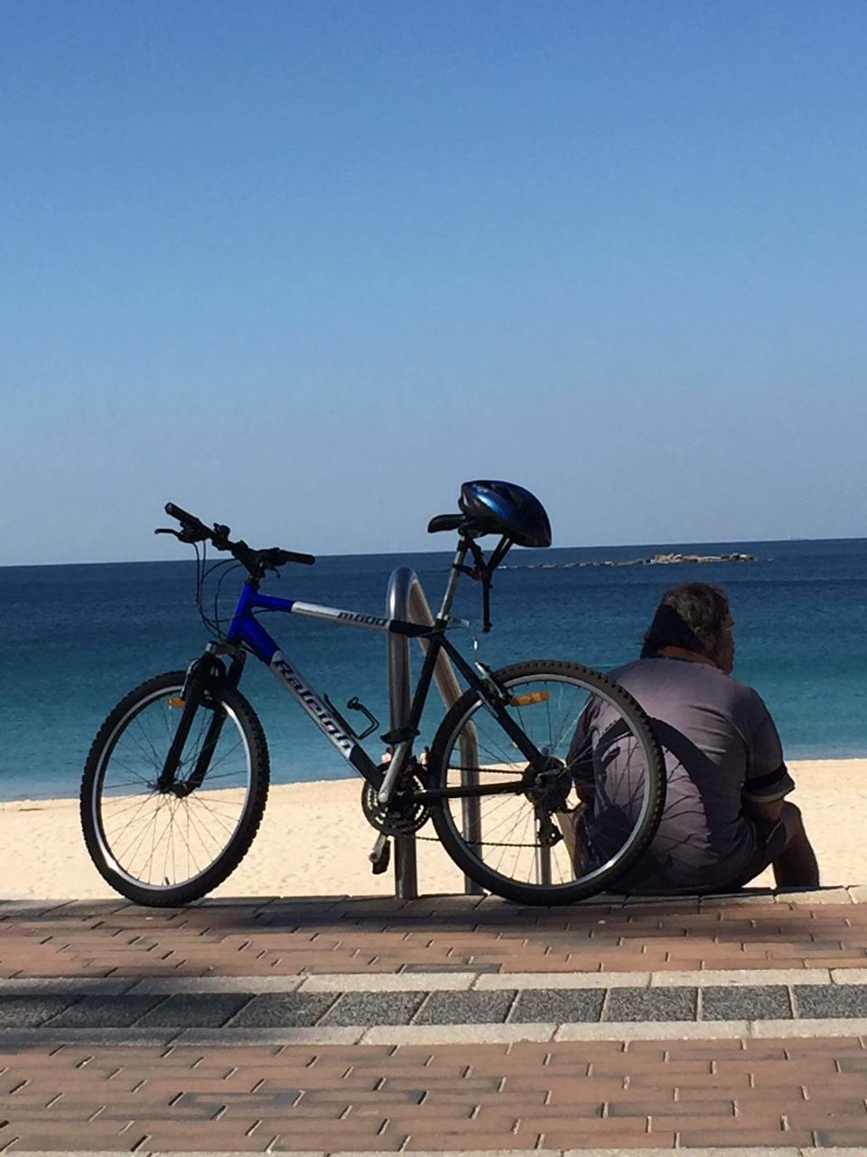 water, sea, sky, horizon over water, transportation, real people, horizon, mode of transportation, bicycle, nature, clear sky, blue, beauty in nature, copy space, land vehicle, lifestyles, people, leisure activity, day, outdoors