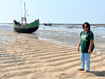 Traveller woman standing on the sand waves in the sea