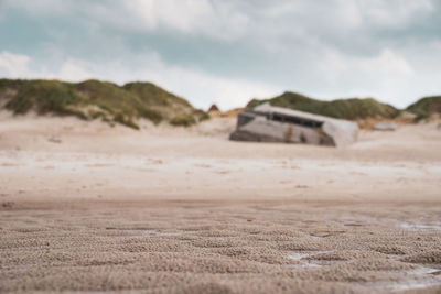 Surface level of sandy beach against sky