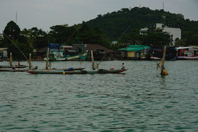 Boats moored in sea against sky