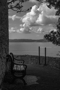 Chair on beach against sky
