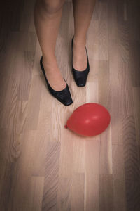 Low section of woman standing on hardwood floor